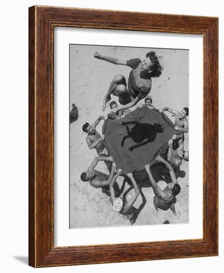 Teenaged Boys Using Blanket to Toss Their Friend, Norma Baker, Into the Air on the Beach-John Florea-Framed Photographic Print