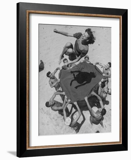 Teenaged Boys Using Blanket to Toss Their Friend, Norma Baker, Into the Air on the Beach-John Florea-Framed Photographic Print