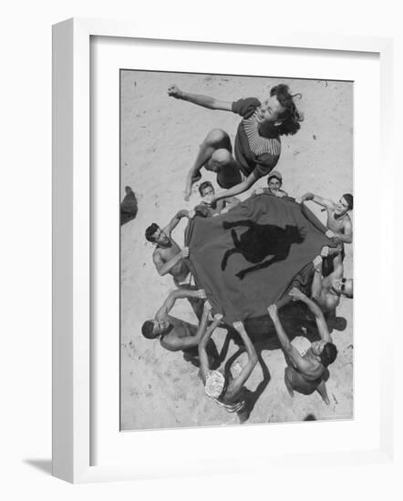 Teenaged Boys Using Blanket to Toss Their Friend, Norma Baker, Into the Air on the Beach-John Florea-Framed Photographic Print