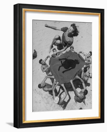 Teenaged Boys Using Blanket to Toss Their Friend, Norma Baker, Into the Air on the Beach-John Florea-Framed Photographic Print