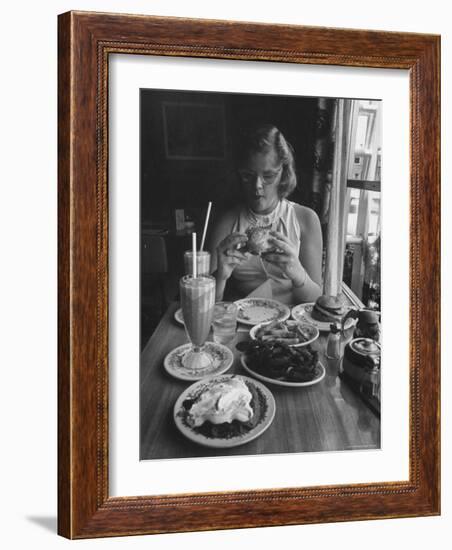 Teenaged Girl Sitting in Drugstore Eating a Hamburger-Hank Walker-Framed Photographic Print