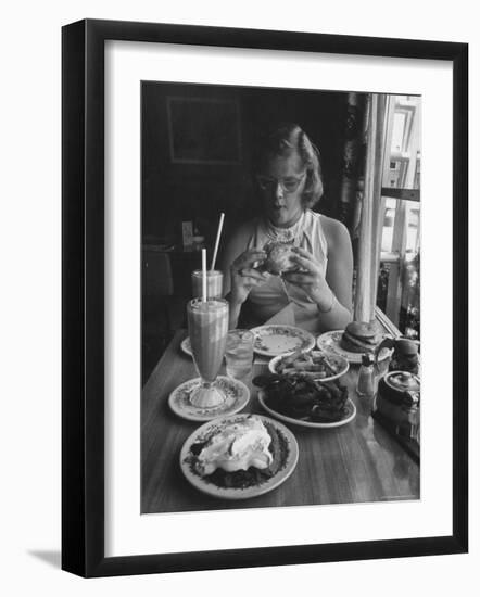 Teenaged Girl Sitting in Drugstore Eating a Hamburger-Hank Walker-Framed Photographic Print
