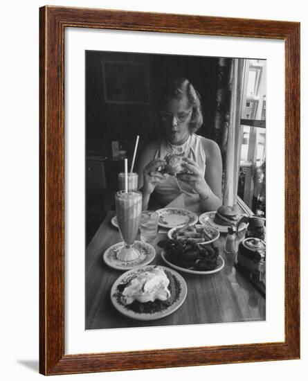 Teenaged Girl Sitting in Drugstore Eating a Hamburger-Hank Walker-Framed Photographic Print