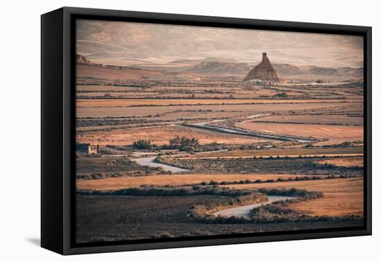 The badlands of Bardenas Reales at sunrise with a winding road leading towards the Castildetierra-Francesco Fanti-Framed Premier Image Canvas