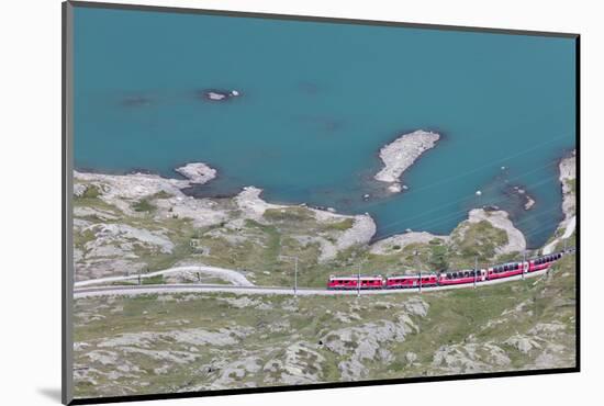 The Bernina Express train passes on the shores of Lago Bianco, Bernina Pass, Canton of Graubunden, -Roberto Moiola-Mounted Photographic Print