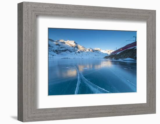 The Bernina Express train runs beside the frozen Lago Bianco, Bernina Pass, canton of Graubunden, E-Roberto Moiola-Framed Photographic Print