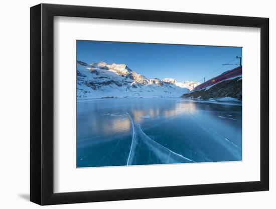 The Bernina Express train runs beside the frozen Lago Bianco, Bernina Pass, canton of Graubunden, E-Roberto Moiola-Framed Photographic Print