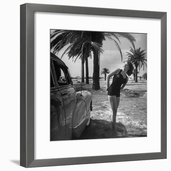 The Cadillac That Has Everything, Jackie Smithwick Taking a Warm Shower Next to the Front Fender-Ed Clark-Framed Photographic Print