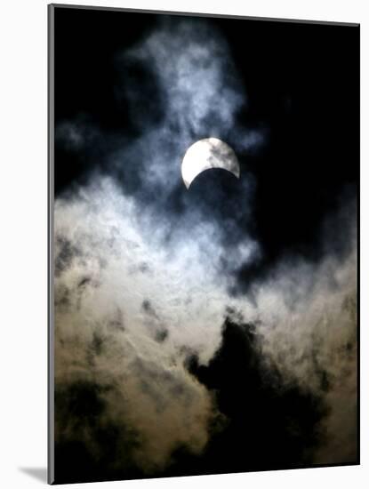 The Moon Partially Covers the Sun Behind the Clouds During a Partial Solar Eclipse-null-Mounted Photographic Print