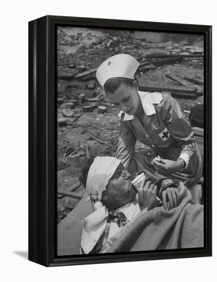 The Red Cross Nurse Trying to Help the Injured Man Eat and Drink-Allan Grant-Framed Premier Image Canvas