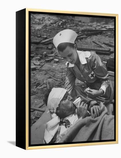 The Red Cross Nurse Trying to Help the Injured Man Eat and Drink-Allan Grant-Framed Premier Image Canvas