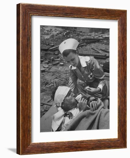 The Red Cross Nurse Trying to Help the Injured Man Eat and Drink-Allan Grant-Framed Photographic Print