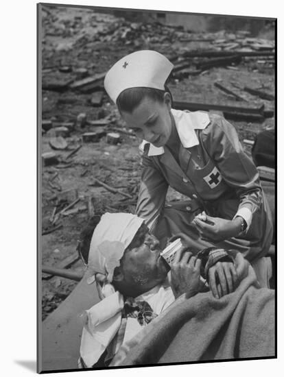 The Red Cross Nurse Trying to Help the Injured Man Eat and Drink-Allan Grant-Mounted Photographic Print