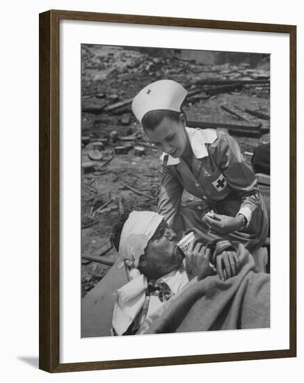 The Red Cross Nurse Trying to Help the Injured Man Eat and Drink-Allan Grant-Framed Photographic Print