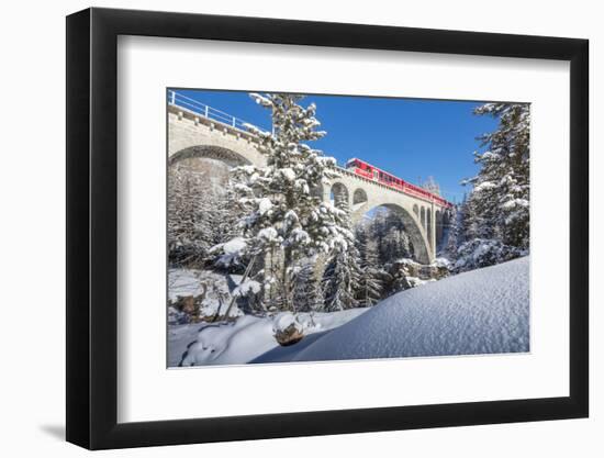 The red train on viaduct surrounded by snowy woods, Cinuos-Chel, Canton of Graubunden, Engadine, Sw-Roberto Moiola-Framed Photographic Print