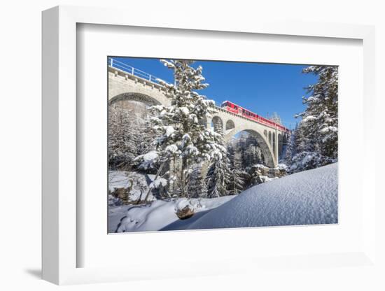 The red train on viaduct surrounded by snowy woods, Cinuos-Chel, Canton of Graubunden, Engadine, Sw-Roberto Moiola-Framed Photographic Print