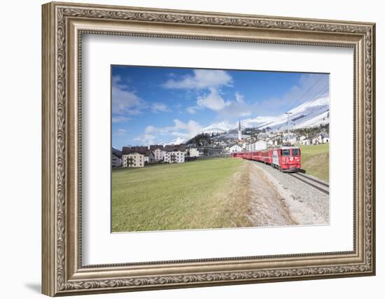 The red train runs across the alpine village of Zuoz in spring, Maloja, Canton of Graubunden, Engad-Roberto Moiola-Framed Photographic Print