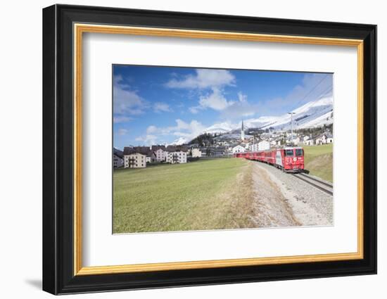 The red train runs across the alpine village of Zuoz in spring, Maloja, Canton of Graubunden, Engad-Roberto Moiola-Framed Photographic Print