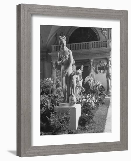 The Statue of Aphrodite and Eros in Louvre Museum During a Flower Show-Dmitri Kessel-Framed Photographic Print