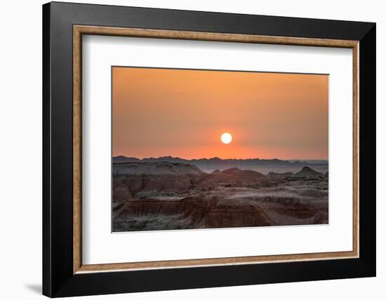 The sun setting over the landscape of hoodoos and hills of Badlands National Park.-Sheila Haddad-Framed Photographic Print