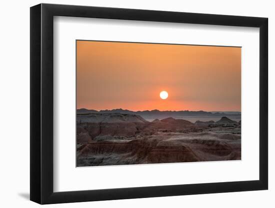 The sun setting over the landscape of hoodoos and hills of Badlands National Park.-Sheila Haddad-Framed Photographic Print