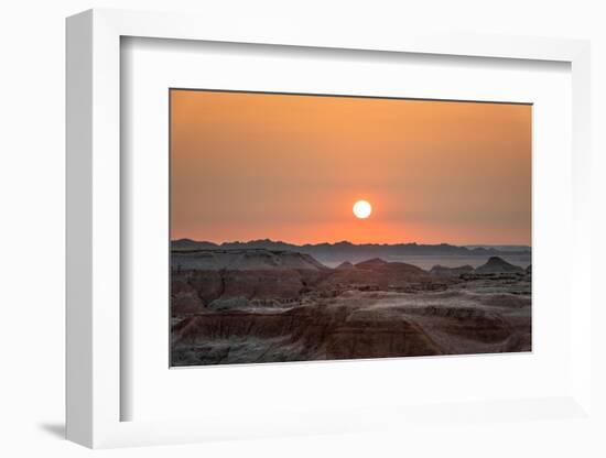 The sun setting over the landscape of hoodoos and hills of Badlands National Park.-Sheila Haddad-Framed Photographic Print