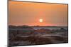 The sun setting over the landscape of hoodoos and hills of Badlands National Park.-Sheila Haddad-Mounted Photographic Print