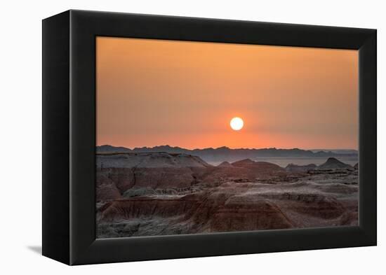 The sun setting over the landscape of hoodoos and hills of Badlands National Park.-Sheila Haddad-Framed Premier Image Canvas