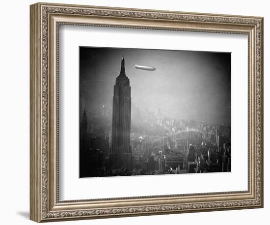 The Zeppelin Hindenburg Floats Past the Empire State Building--Framed Photographic Print