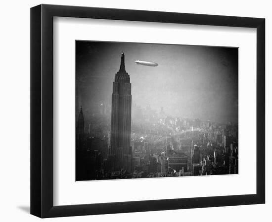 The Zeppelin Hindenburg Floats Past the Empire State Building--Framed Photographic Print