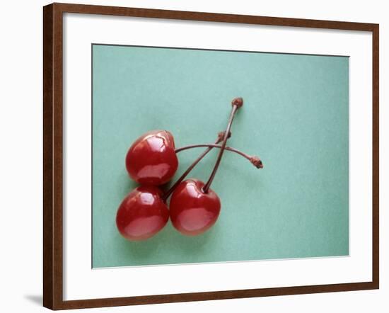 Three Cherries on a Green Background-Karen M^ Romanko-Framed Photographic Print