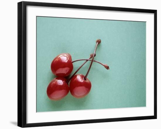 Three Cherries on a Green Background-Karen M^ Romanko-Framed Photographic Print