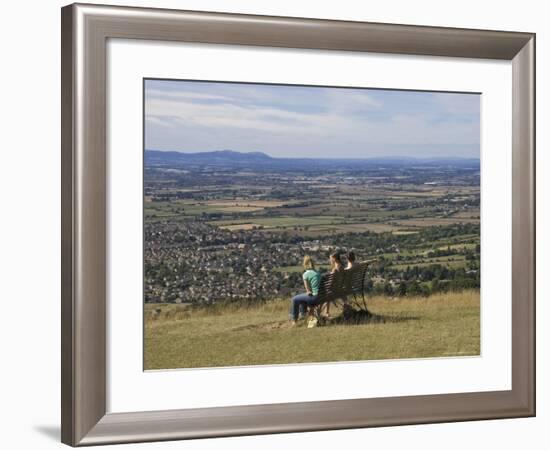 Three Girls Sitting on Bench Looking at View Over Bishops Cleeve Village, the Cotswolds, England-David Hughes-Framed Photographic Print