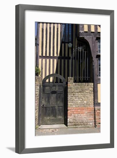 Timber Framed Building with Gate and Brick Wall in Tudor-Style House-Natalie Tepper-Framed Photo