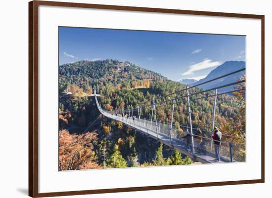 Tourists on the suspension bridge called Highline 179 framed by colorful woods in autumn, Ehrenberg-Roberto Moiola-Framed Photographic Print