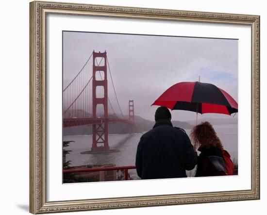 Tourists Use an Umbrella During a Light Rain, Looking at the Golden Gate Bridge in San Francisco-null-Framed Photographic Print