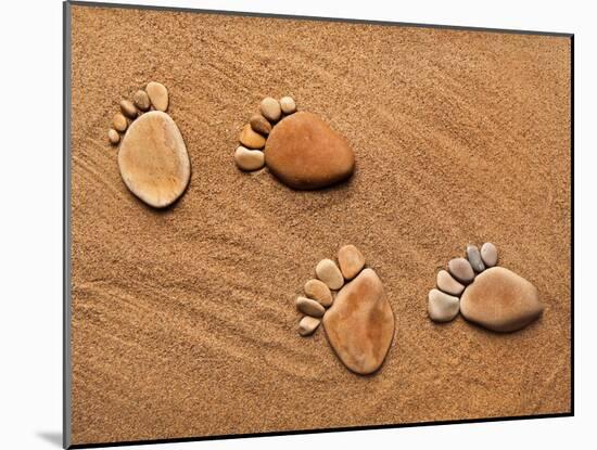 Trace Feet Steps Made Of A Pebble Stone On The Sea Sand Backdrop-Madlen-Mounted Photographic Print