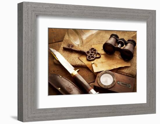 Treasure Hunting Setting, A Compass, Binoculars, Knife and a Old Key on a Old Wooden Desk-landio-Framed Photographic Print