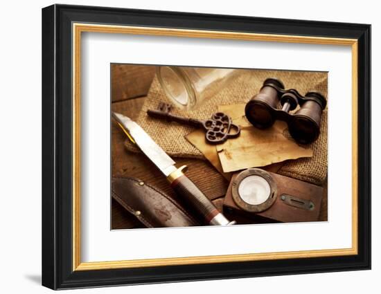 Treasure Hunting Setting, A Compass, Binoculars, Knife and a Old Key on a Old Wooden Desk-landio-Framed Photographic Print