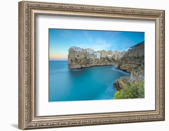 Turquoise sea at sunset framed by the old town perched on the rocks, Polignano a Mare, Province of -Roberto Moiola-Framed Photographic Print