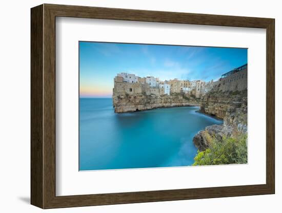 Turquoise sea at sunset framed by the old town perched on the rocks, Polignano a Mare, Province of -Roberto Moiola-Framed Photographic Print