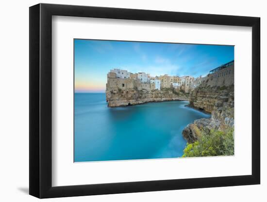 Turquoise sea at sunset framed by the old town perched on the rocks, Polignano a Mare, Province of -Roberto Moiola-Framed Photographic Print