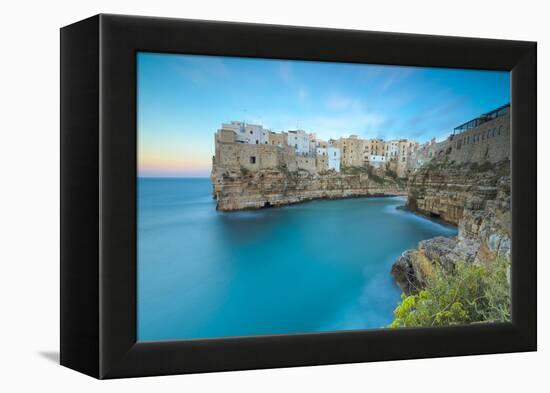 Turquoise sea at sunset framed by the old town perched on the rocks, Polignano a Mare, Province of -Roberto Moiola-Framed Premier Image Canvas