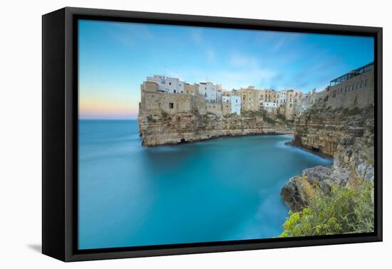 Turquoise sea at sunset framed by the old town perched on the rocks, Polignano a Mare, Province of -Roberto Moiola-Framed Premier Image Canvas