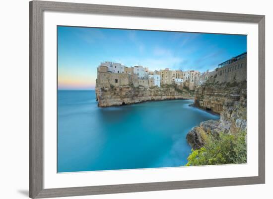 Turquoise sea at sunset framed by the old town perched on the rocks, Polignano a Mare, Province of -Roberto Moiola-Framed Photographic Print