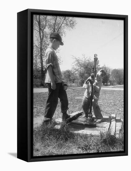 Two Boys Getting Water from a Pump at Rural School-Thomas D^ Mcavoy-Framed Premier Image Canvas