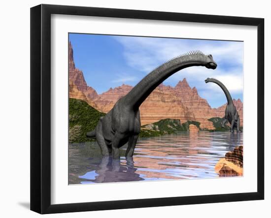 Two Brachiosaurus Dinosaurs in Water Next to Red Rock Mountains-null-Framed Art Print