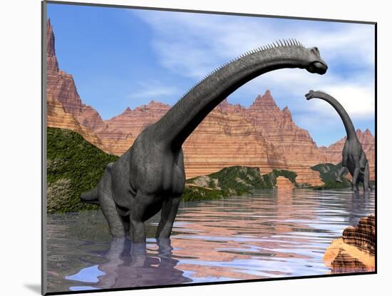 Two Brachiosaurus Dinosaurs in Water Next to Red Rock Mountains-null-Mounted Art Print