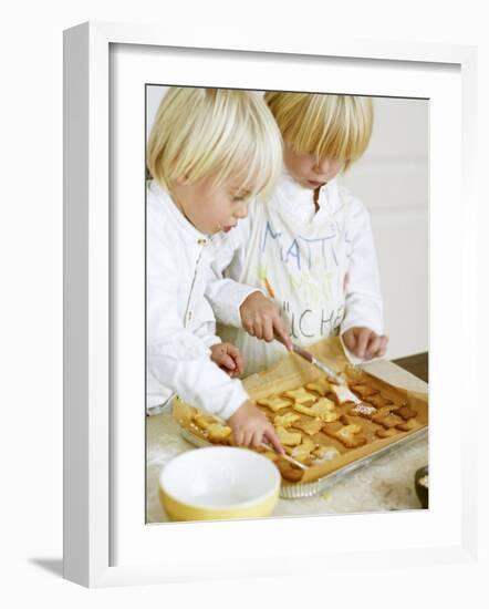 Two Children Brushing Biscuits with Glace Icing-Renate Forster-Framed Photographic Print