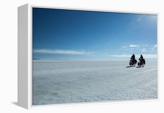 Two Cyclists Cycle in the Morning over the Salar De Uyuni-Alex Saberi-Framed Premier Image Canvas